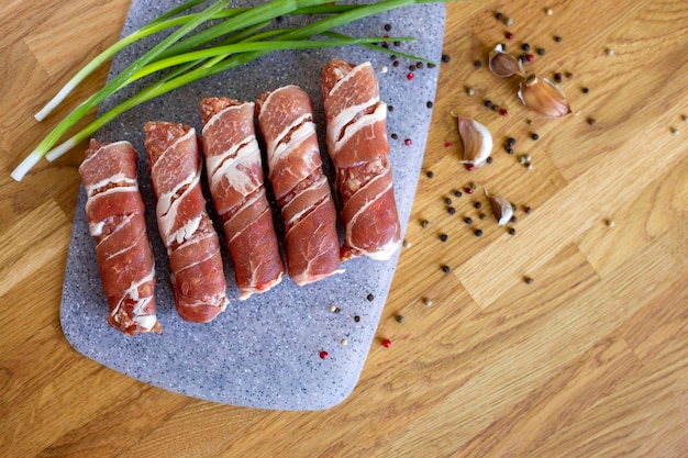 Chevapchichi sul tavolo di legno vista dall'alto carne macinata avvolta in pancetta kofta kebab