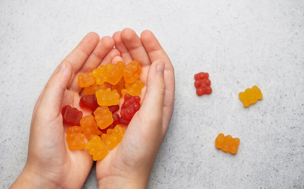 Photo chewable gummy bears vitamins and supplements a girl holds a gummy bear vitamines in her hands