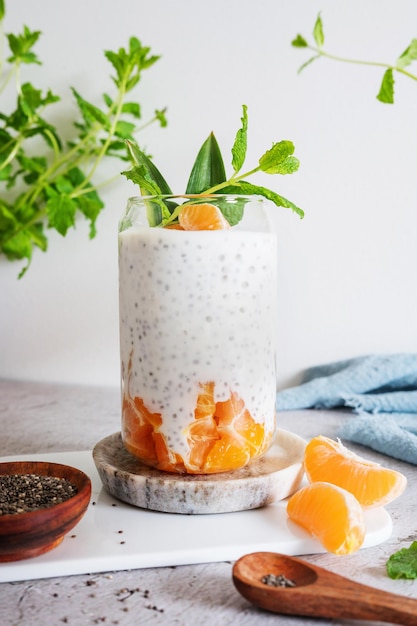 Chia pudding in glass with yogurt or coconut milk and clementine