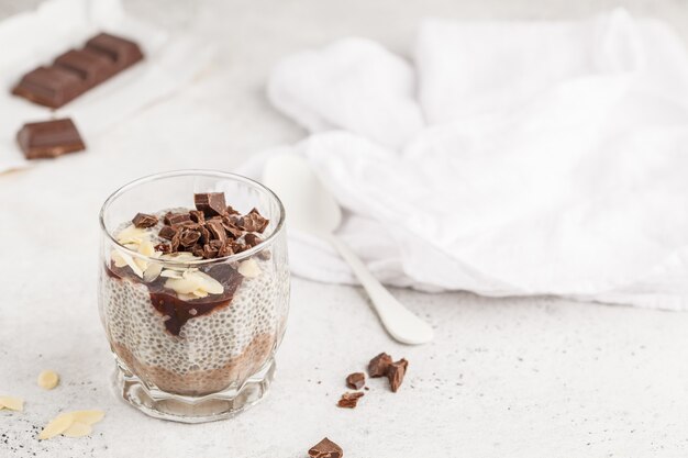 Chia pudding met chocolade, amandelen en bessenjam, exemplaarruimte. ruw veganistdessert.