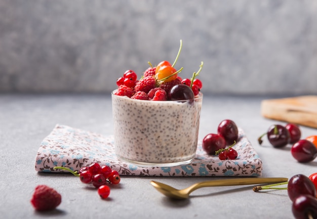 Chia pudding met kers, framboos, bes in glazen kom