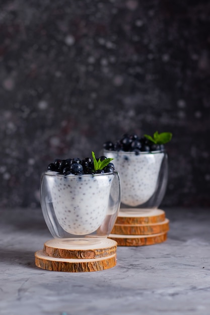 Chia pudding met munt en bosbessen in glazen op een houten voet