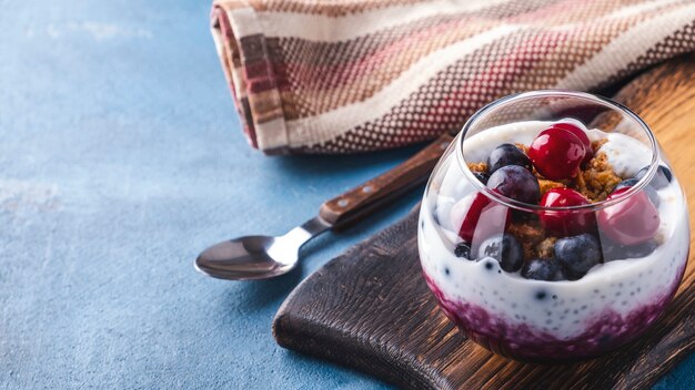 Chia pudding with berries in a glass bowl with copy space.