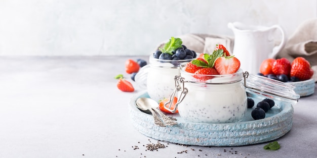 Photo chia pudding with berries in glass jar.