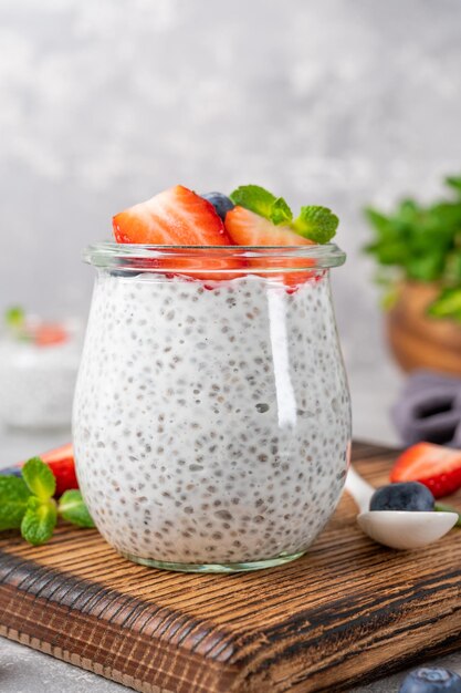 Chia pudding with fresh strawberry and blueberry on top in a jar Healthy breakfast Copy space