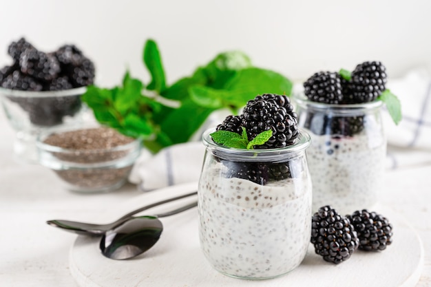 Chia pudding with mint leaves and blackberries on white