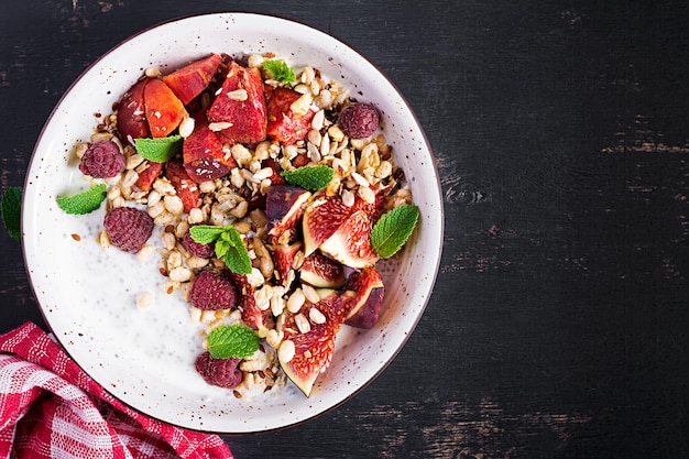 Chia seed pudding made with raspberries figs and mint on dark background The concept of good nutrition Top view