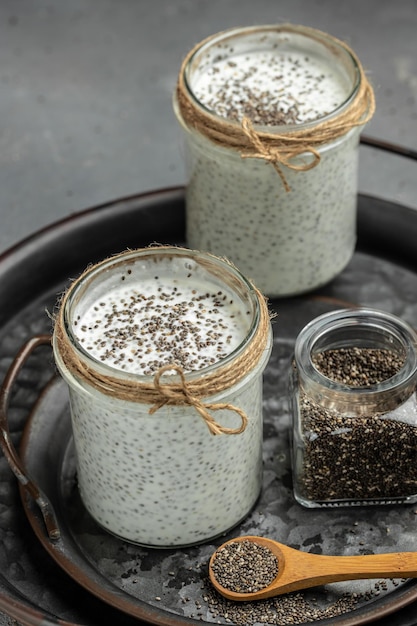 Chia Seed with lactosefree yogurt on gray background Yogurt with chia seeds healthy superfood Cottage cheese smoothie in glass vertical image place for text