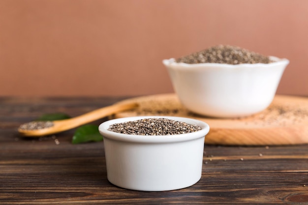 Chia seeds in bowl and spoon on colored background Healthy Salvia hispanica in small bowl Healthy superfood