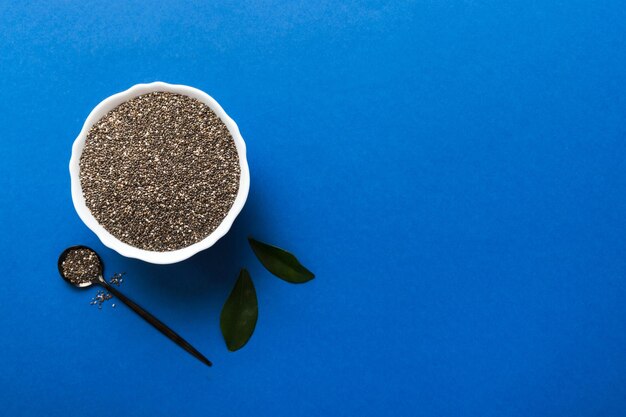 Chia seeds in bowl and spoon on colored background Healthy Salvia hispanica in small bowl Healthy superfood