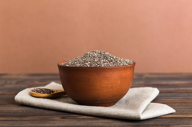 Chia seeds in bowl and spoon on colored background Healthy Salvia hispanica in small bowl Healthy superfood