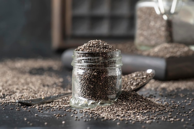 Chia seeds in glass jar dark background selective focus