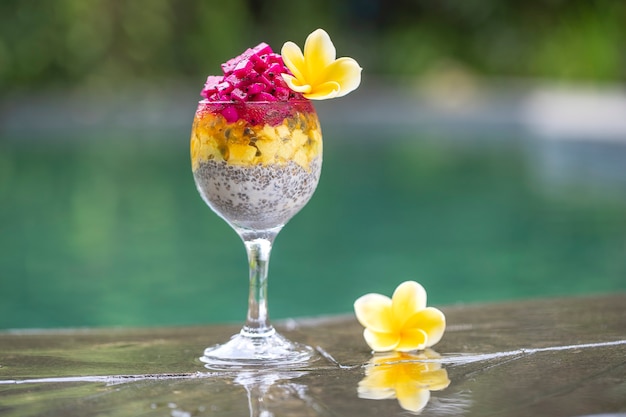 Chia seeds pudding with red dragon fruit, passion fruit, mango and avocado in a glass