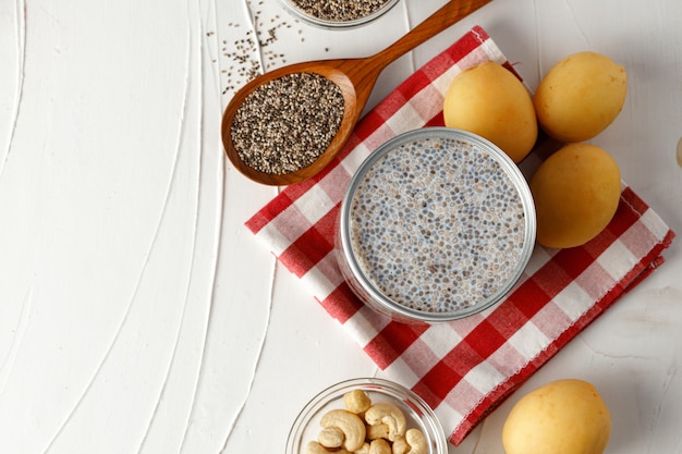 Chia seeds with berry and nuts on white table