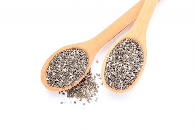 Chia seeds and wooden spoons isolated on white