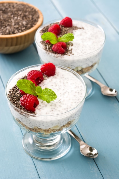 Chia yogurt with raspberries on blue wood