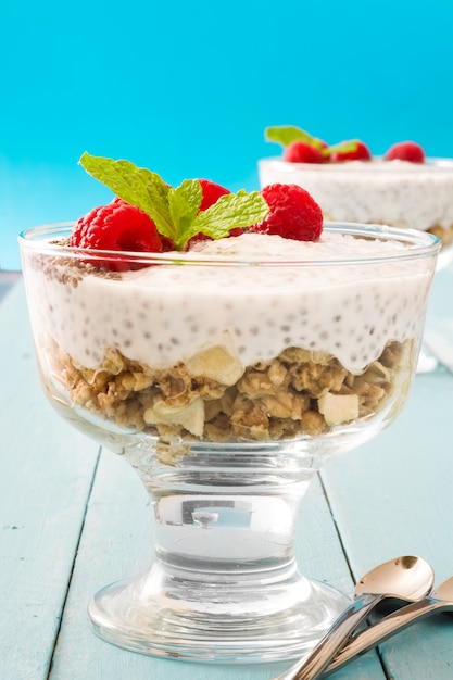 Chia yogurt with raspberries on blue wood