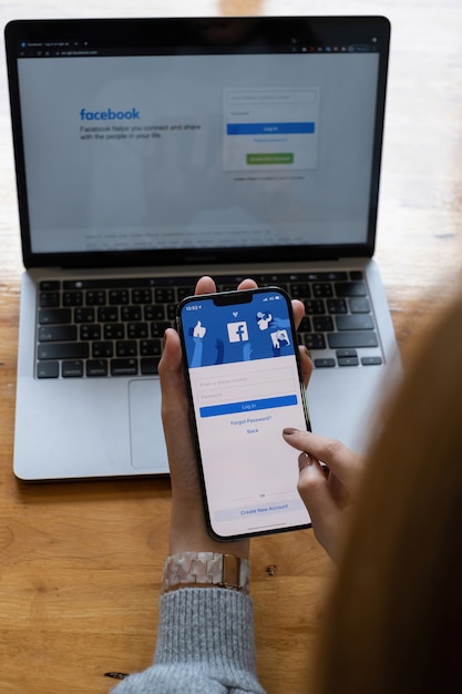 Foto chiang mai, thailandia - 18 ottobre 2021: una donna tiene in mano l'apple iphone 6s con l'applicazione facebook sullo schermo. facebook è un'app per la condivisione di foto per smartphone. facebook è un social network.