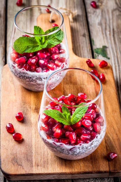 Chiapudding met granaatappelpitjes en munt op rustieke houten tafel