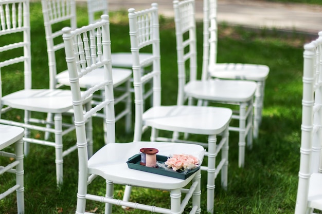 Chiavari stoelen op gras Op een van de stoelen lagen rozen en linten