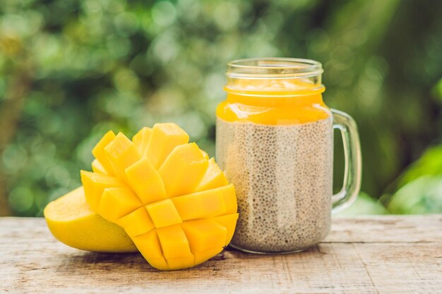 Chiazaadpudding met amandelmelk en verse mango topping op een houten tafel