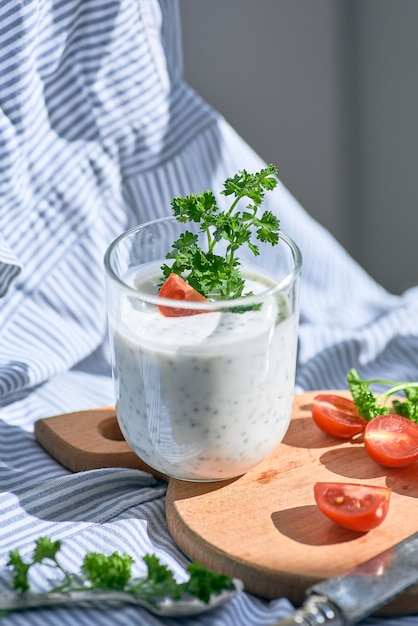 Chiazaden en yoghurt in een glas met greens en tomaten