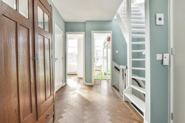 A chic hall with soft blue walls and a spiral staircase