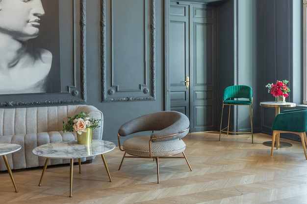 Шикарный интерьер комнаты в стиле ренессанс 19 века с современной роскошной мебелью. стены благородного темного цвета украшены лепниной и позолоченными рамами, деревянным паркетом.