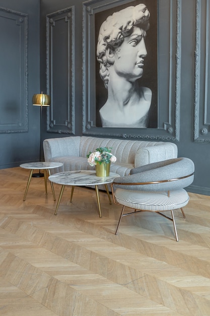 Interni chic della stanza in stile rinascimentale del xix secolo con mobili di lusso moderni. le pareti di nobile colore scuro sono decorate con stucchi e cornici dorate, parquet in legno.