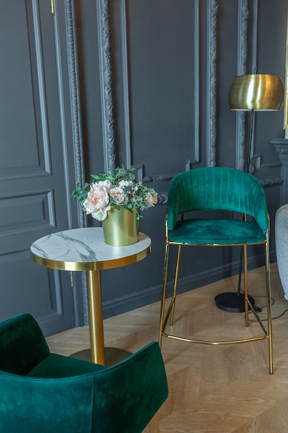 Chic interior of the room in the Renaissance style of the 19th century with modern luxury furniture. walls of noble dark color are decorated with stucco and gilded frames, wooden parquet.