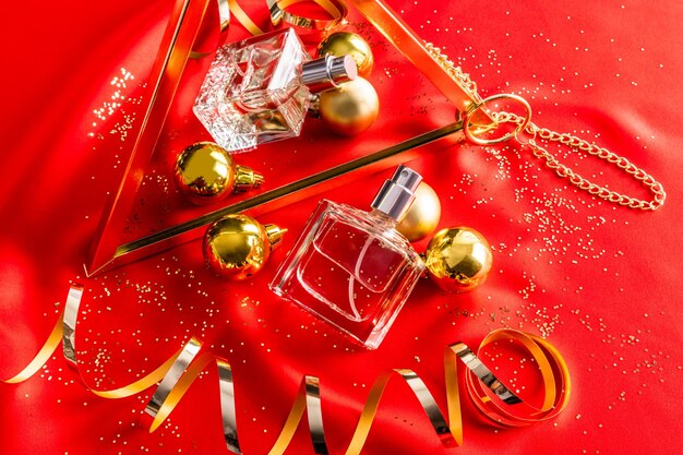 A chic perfume bottle is reflected in a mirror against of a golden serpentine red satin background new year's presentation of the fragrance