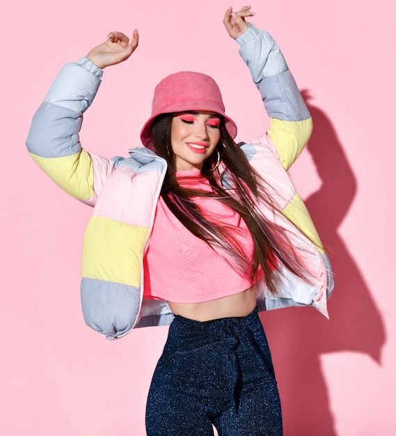 Foto modello di ragazza adolescente chic in movimento ritratto in studio di bellezza isolato su sfondo rosa bella giovane donna che indossa giacca tshirt e cappello che balla danza sensuale per la fotocamera moda per adolescenti e giovani