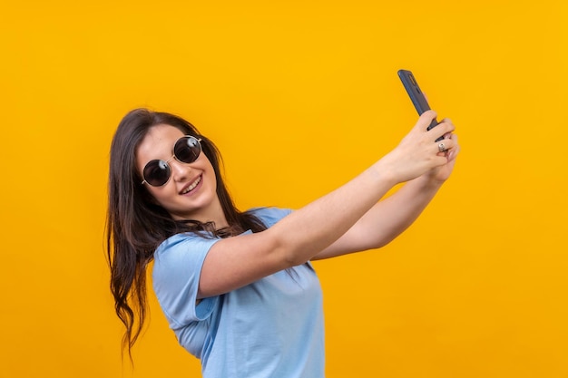 Chic vrouw met zonnebril die een selfie maakt