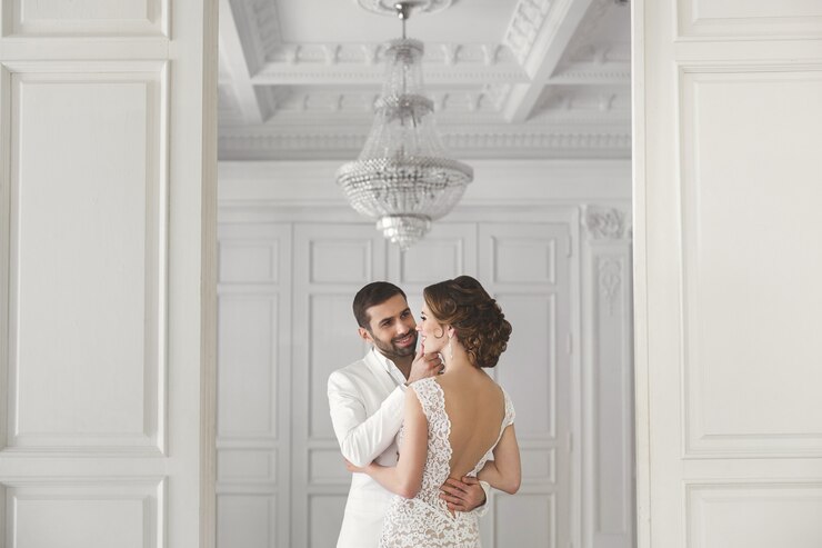 Photo chic wedding couple groom and bride posing in a white studio