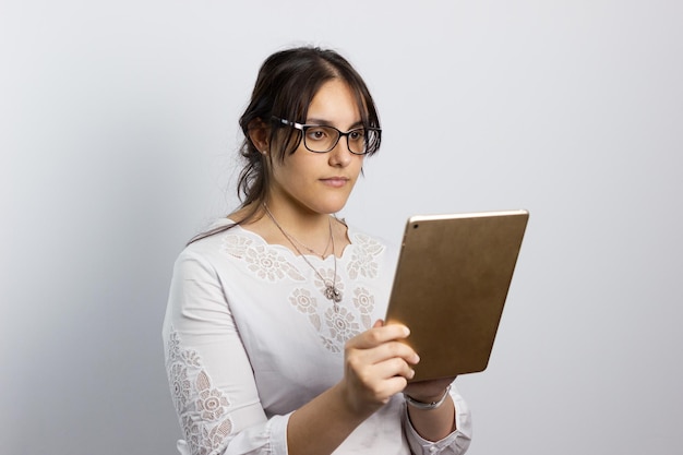 Chica joven gebruik een tablet sobre un fondo blanco