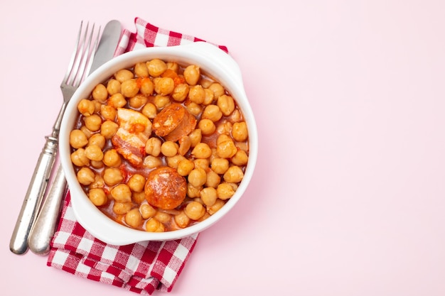 Chick-pea with smoked sausage in white bowl