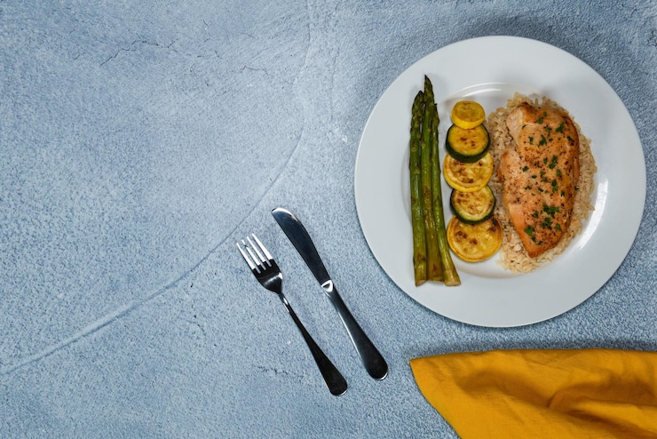 Photo chicken breast on a bed of brown rice with a side of asparagus and zucchini