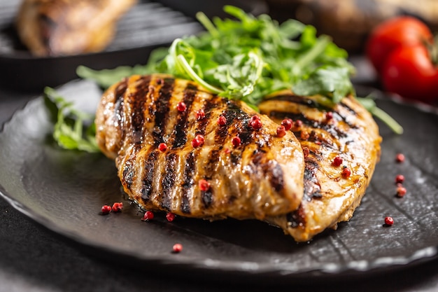 Petto di pollo alla griglia con spezie pepe sale pomodori e rucola.