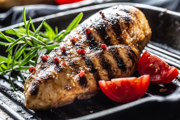 Chicken breast grilled with spices peper salt tomatoes and rosemary.