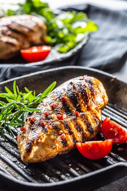 Chicken breast grilled with spices peper salt tomatoes and rosemary.