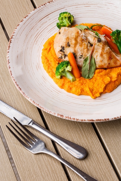 Foto bistecca di petto di pollo con purea di carote baby carota e broccoli.