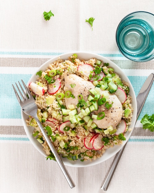 Photo chicken breast with couscous, cucumber, avocado, spring onion, radish. healthy lunch