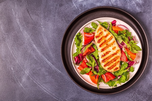 Chicken breast with fresh salad, top view.