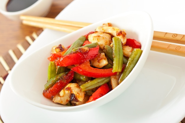 Chicken breast with vegetables and sauce decorated with basil leaves