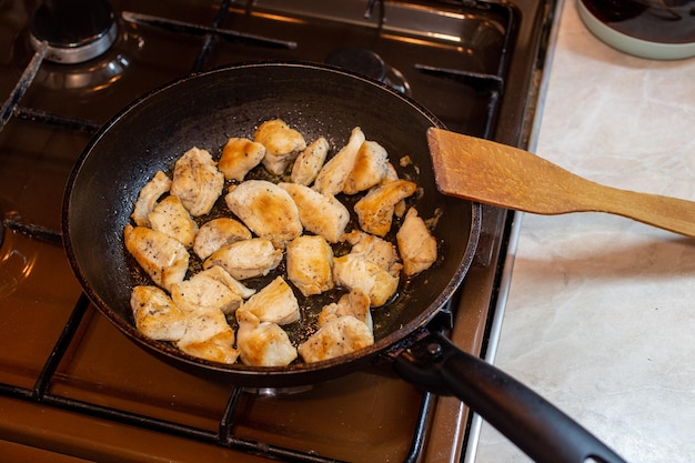 Foto pelle di pollo carne solo su padella e spatola di legno cucina domestica sana nella vita reale