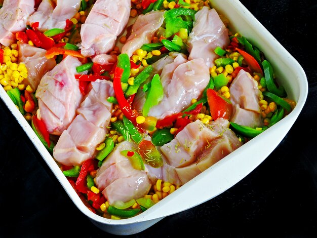 Chicken breasts with corn and vegetables in Mexican style before baking