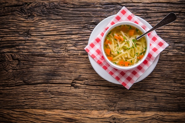 Chicken broth.Beef Broth. Bone broth with noodles carrot and parsley in white bowl.