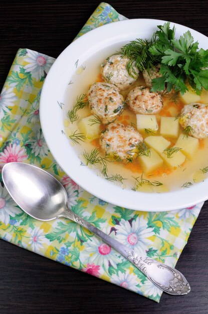 Chicken broth of potatoes, carrots and meatballs sprinkled with dill