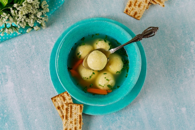 Chicken broth with matzo balls and matzos bread.