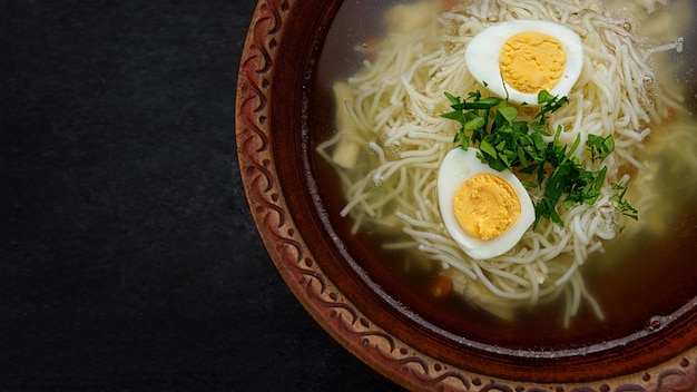 Chicken broth with noodles herbs and egg studio light